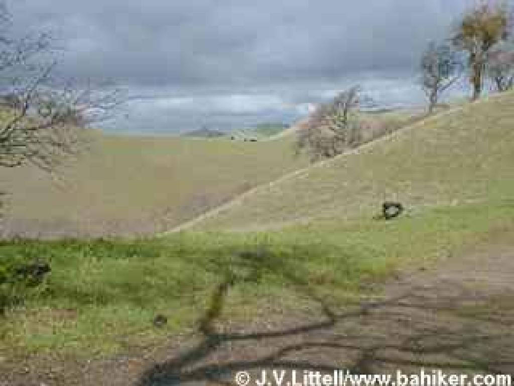 Darkening skies over green hills