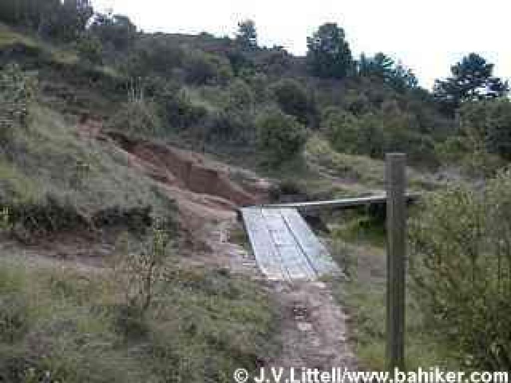 A rough bridge crosses a washed-out section